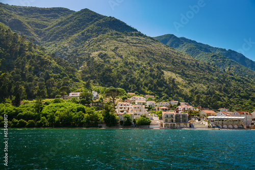 Beautiful green hills and old stone houses on the shore of Boka Kotor bay