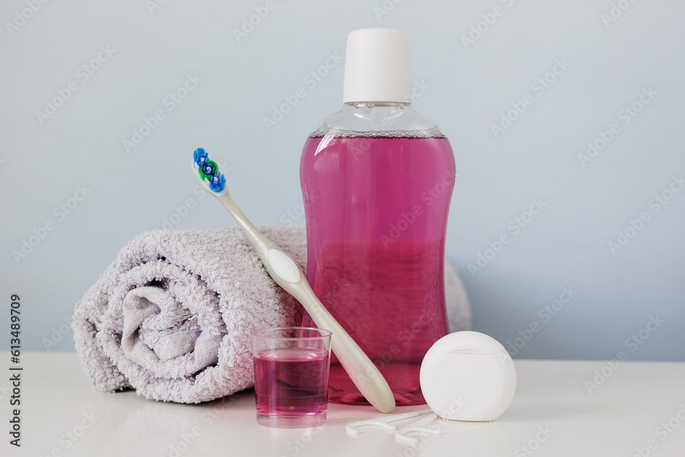 Bottle of mouthwash, toothbrush and dental floss on table Bottle of mouthwash, toothbrush and dental floss on table