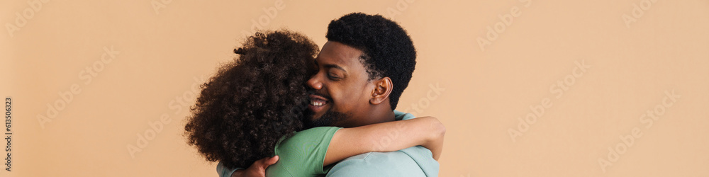 Black man and woman expressing happiness and hugging together Black man and woman expressing happiness and hugging together