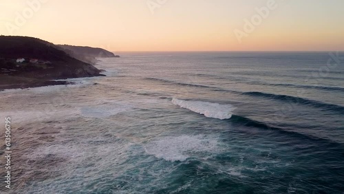 Foamy Waves Rolling On The Beach In Arteixo, Spain At Sunset - drone shot, slow motion photo