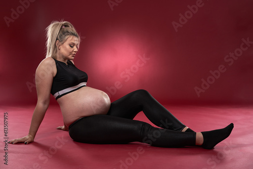 Pregnant woman in black over red background
