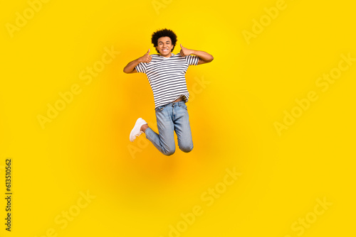 Full body photo of active jumping guy thumbs up recommendation cool proposition black friday shopping isolated on yellow color background
