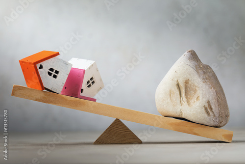 Stone and houses on the scales, a concept on the theme of real estate transactions, a template for the designer photo