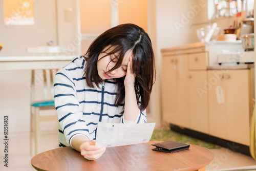 電気料金の高騰で頭を抱える若い女性 © maroke