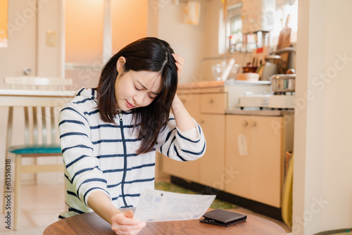 電気料金の高騰で頭を抱える若い女性 © maroke