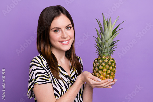 Photo of young cheerful girl hold fresh ripe ananas eat sweet dessert juicy exotic tropical fruit isolated on purple color background