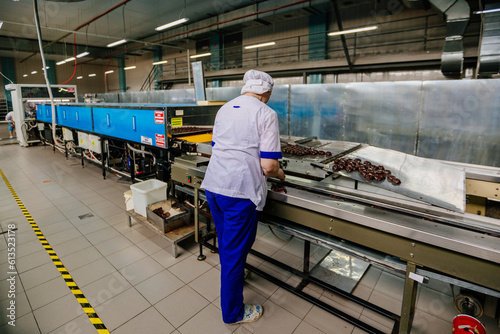 Confectionery worker sorting zephyrs on conveyor