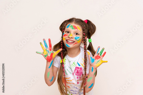 Painted hands and face. Portrait of a girl child stained in multicolored paint. Children s artistic creativity. Isolated white background.