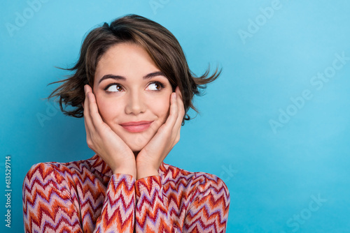 Photo of thoughtful pretty woman dressed striped top arms cheeks looking empty space isolated blue color background