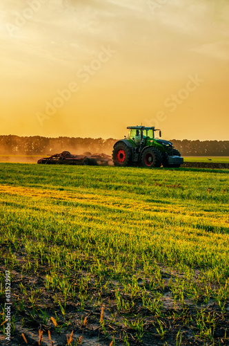 tractor in the field under sunset light  tillage in spring. selective focus. High quality photo