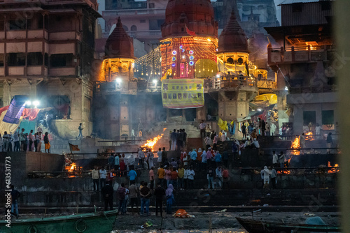 India Varanasi ganga ghat at night, view of the crowded banks of people and funeral pyres