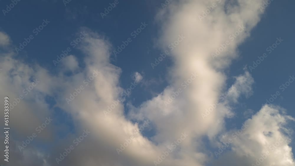 Golden-hued clouds move across the sky as they become more golden Golden-hued clouds move across the sky as they become more golden