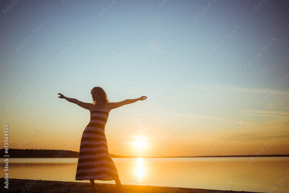 Silhouette of a full length woman posing on sea beach at sunset. Profile of sexy body. Seascape background. Morning time walk. Copy space. Happy person. Summer time vacation. Model photo. Happiness