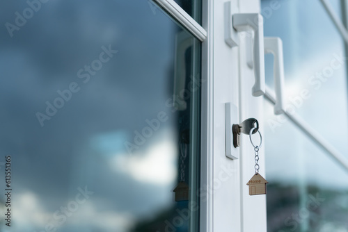 Landlord key for unlocking house is plugged into the door. Second hand house for rent and sale. keychain is blowing in the wind. mortgage for new home, buy, sell, renovate, investment, owner, estate..