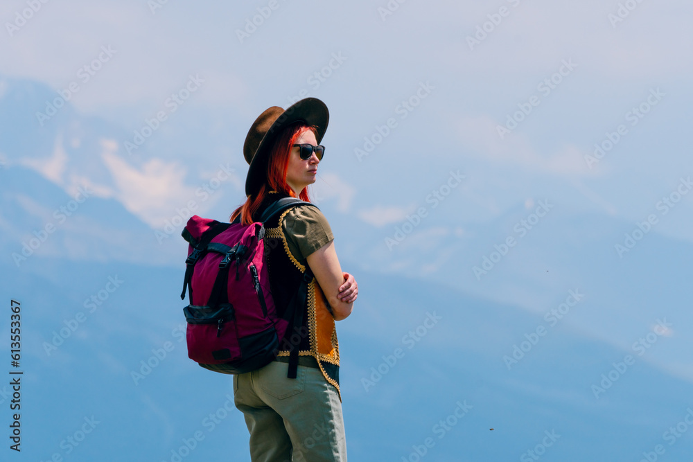 Woman in wide sun hat and backpack, tourist on hiking route to Koruldi Lakes, Svaneti region, Mestia Georgia. The concept of travel and active recreation. Summer day