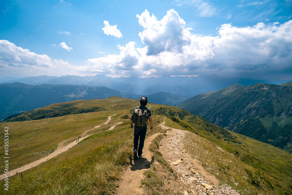 Man hiking to Koruldi lakes, beautiful view of Great Caucasus mountains close to Mestia in Upper Svaneti, Georgia. Summer day