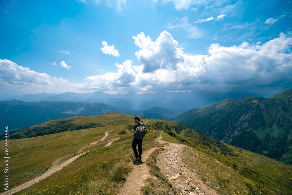 Man hiking to Koruldi lakes, beautiful view of Great Caucasus mountains close to Mestia in Upper Svaneti, Georgia. Summer day
