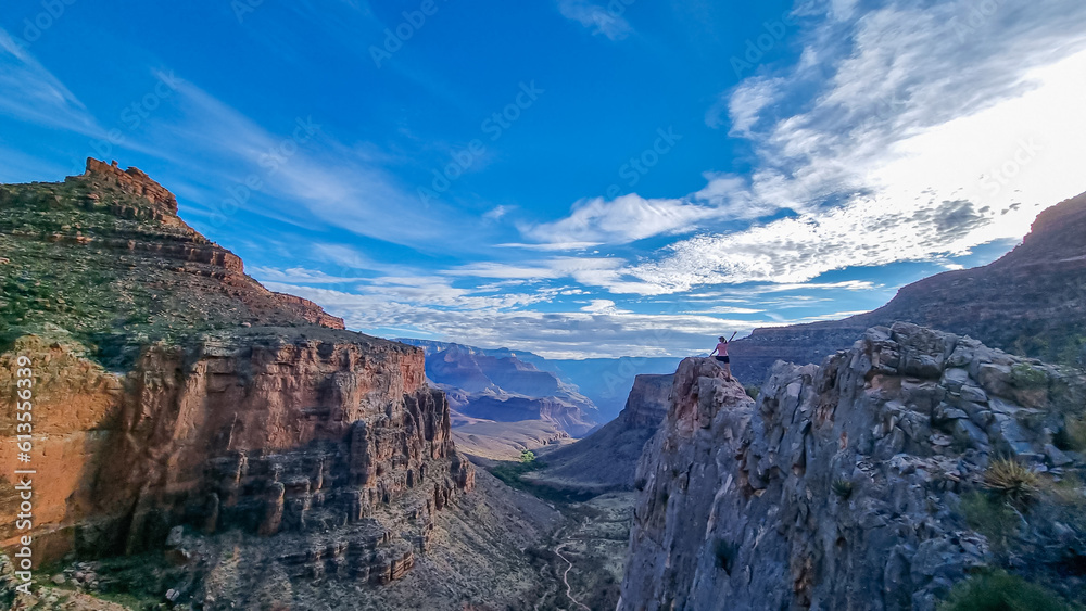 Silhouette of woman standing on edge of rock formation overlooking the South Rim of National Park, Arizona, USA, America. Aerial views on Bright Angel and Plateau Point hiking trail in summer. Freedom