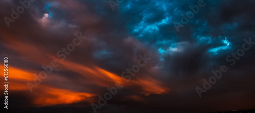 Colorful sunset with dark clouds. Natural beautiful landscape of sky. Panoramic banner view.
