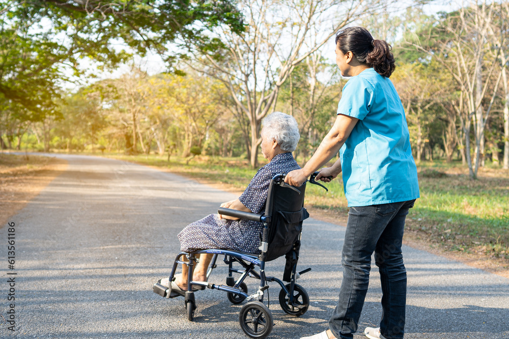 Caregiver help and care Asian elderly woman on wheelchair at park with happy in holiday. Caregiver help and care Asian elderly woman on wheelchair at park with happy in holiday.