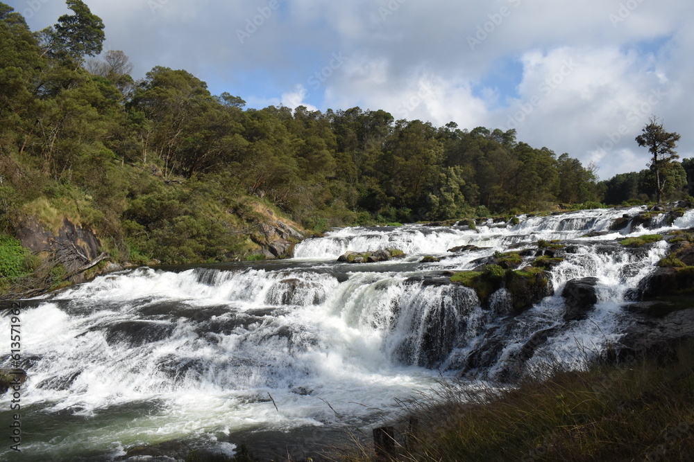 River flowing with green hills and blue sky River flowing with green hills and blue sky