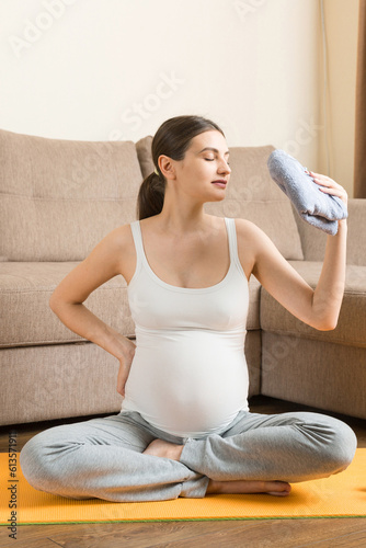 pregnant girl doing yoga with dumbbells at home on a sunny day. coronavirus at home