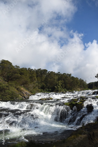 River flowing with green hills and blue sky