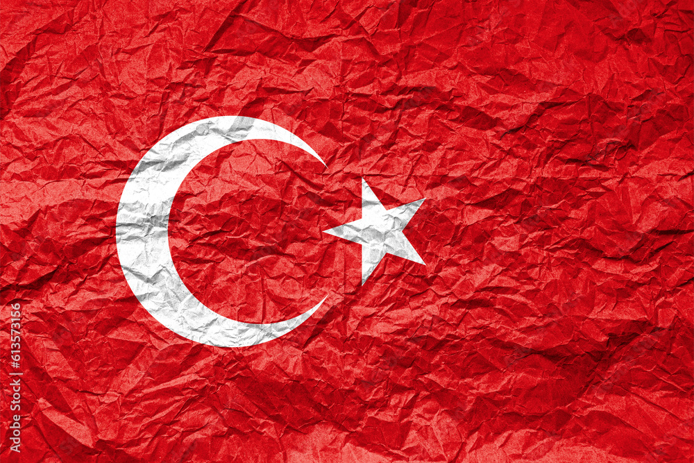 Flag of Turkiye on crumpled paper. Textured background.