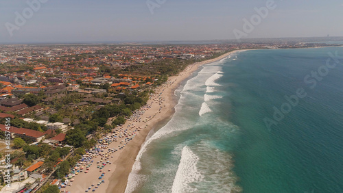 Aerial view sand beach with resting people, hotels and tourists, sun umbrellas, Bali, Kuta. surfers on water surface. Seascape, beach, ocean, sky sea Travel concept