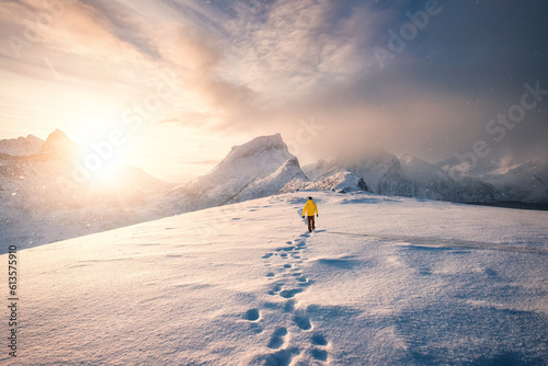 Mountaineer walking with footprint in snow storm and sunrise over snowy mountain Fototapet