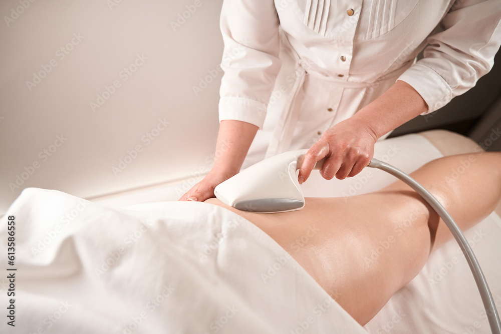 Fototapeta premium Specialist masseur makes a hardware foot massage for a client