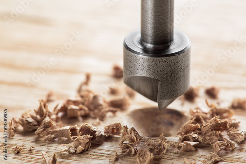 Countersink drill bit with steel triangle ruler make sink in hole for screw in wooden oak plank