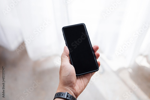 Man holding smart phone with blurred background. For Graphic display montage , man using mobile smart phone