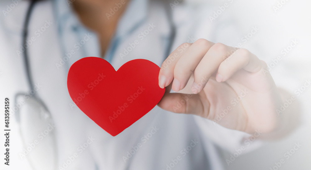 male doctor holding a red heart with his hand on his chest male doctor holding a red heart with his hand on his chest