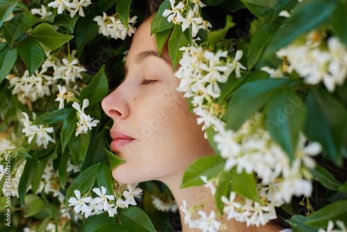 Spring perfume. Profile beauty outdoor portrait of young woman in white blooming flower