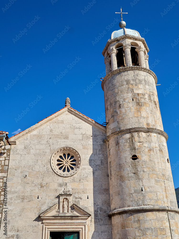 Facade with a rose window and tower of the Church of Our Lady of the Rocks. It is in an artificial island in the Adriatic sea. Perast, Kotor Bay,  Montenegro