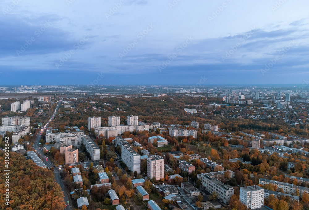 Aerial autumn evening city view. Residential district with park and dark blue cloudy sky. Kharkiv, Ukraine