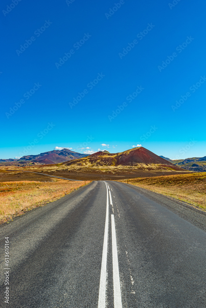 Cover page with a paved road and Icelandic colorful and wild landscape with fjords and sea at summer time, West Iceland