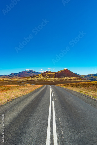 Cover page with a paved road and Icelandic colorful and wild landscape with fjords and sea at summer time, West Iceland
