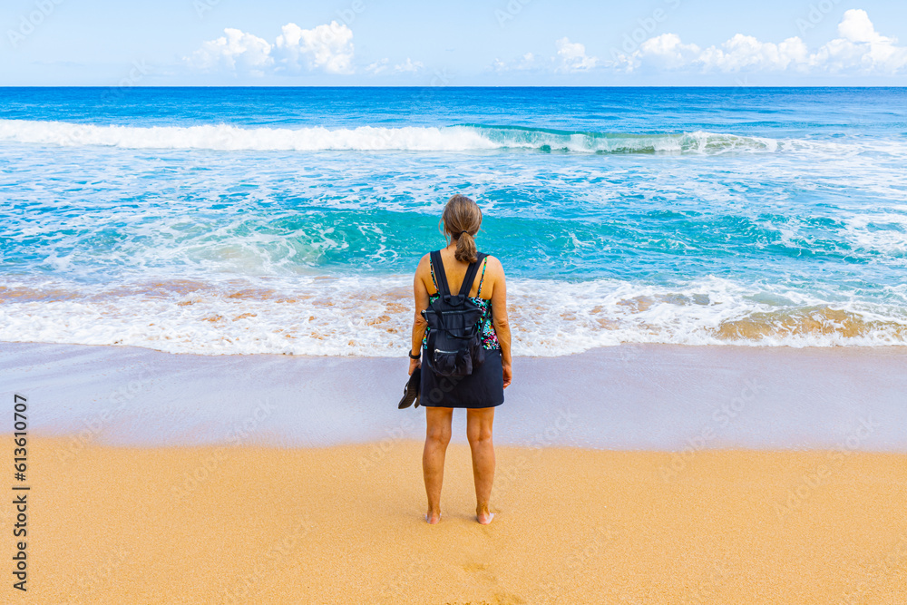 Female Tourist on The Sandy Shore of Kauapea Beach, Kauai, Hawaii, USA Female Tourist on The Sandy Shore of Kauapea Beach, Kauai, Hawaii, USA