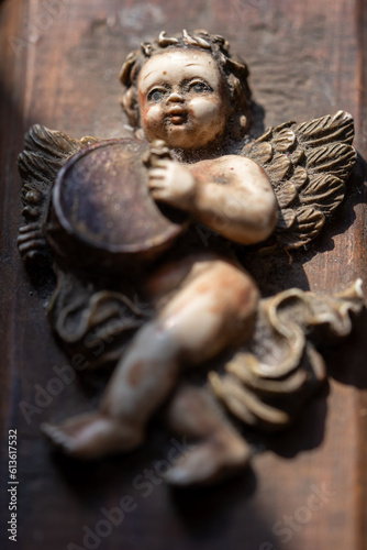 angelito con alas adosado a caja de madera barroca lleno de polvo, olvidado. photo