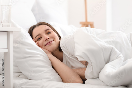 Young woman lying on bed in...