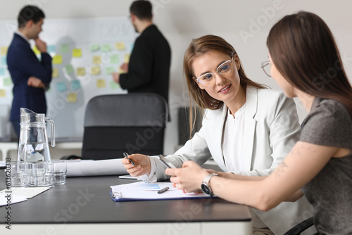 Female colleagues working on business plan in office