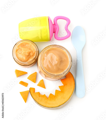 Jars of baby food, pumpkin and nibbler on white background