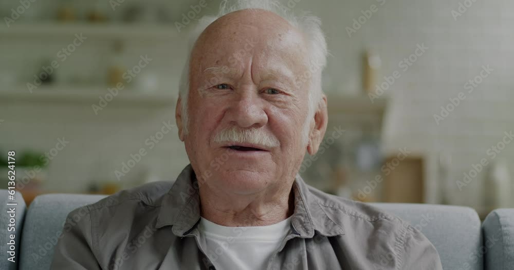 Portrait of elderly man talking and waving hand looking at camera making online video call indoors at home. Communication and senior person concept. Portrait of elderly man talking and waving hand looking at camera making online video call indoors at home. Communication and senior person concept.