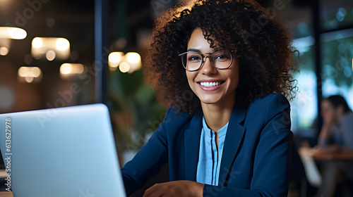 Young curly haired businesswoman working at her laptop