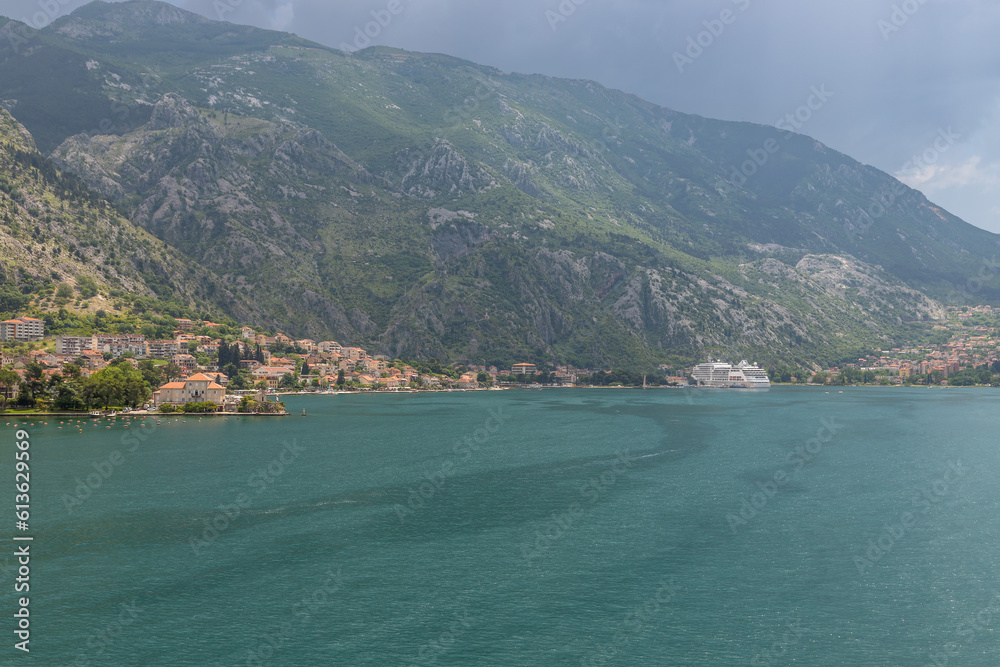 Landscape Exposure done from a cruise ship, showing the sea entrance to Kotor bay and its beautiful coastal landscapes and small villages , on a sunshiny day.