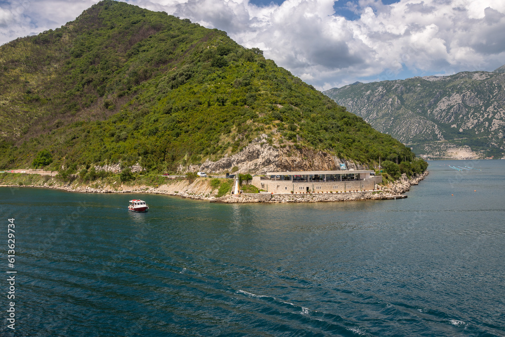 Fototapeta premium Landscape Exposure done from a cruise ship, showing the sea entrance to Kotor bay and its beautiful coastal landscapes and small villages , on a sunshiny day.