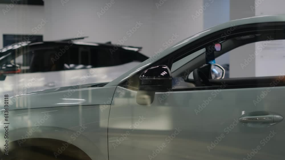 Cars stand in the trading floor of a car dealership, view through the glass Cars stand in the trading floor of a car dealership, view through the glass