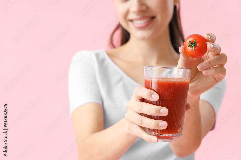 Young woman with glass of vegetable juice and tomato on pink background, closeup Young woman with glass of vegetable juice and tomato on pink background, closeup